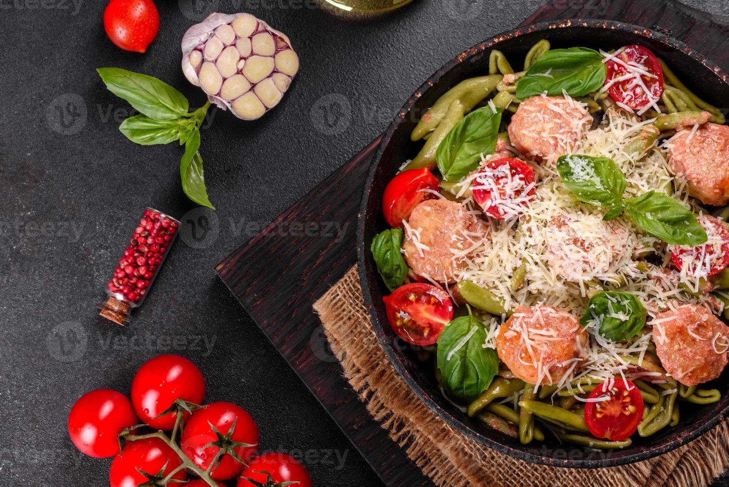 leckere frische Pasta mit Fleischbällchen, Sauce, Cherrytomaten und Basilikum foto