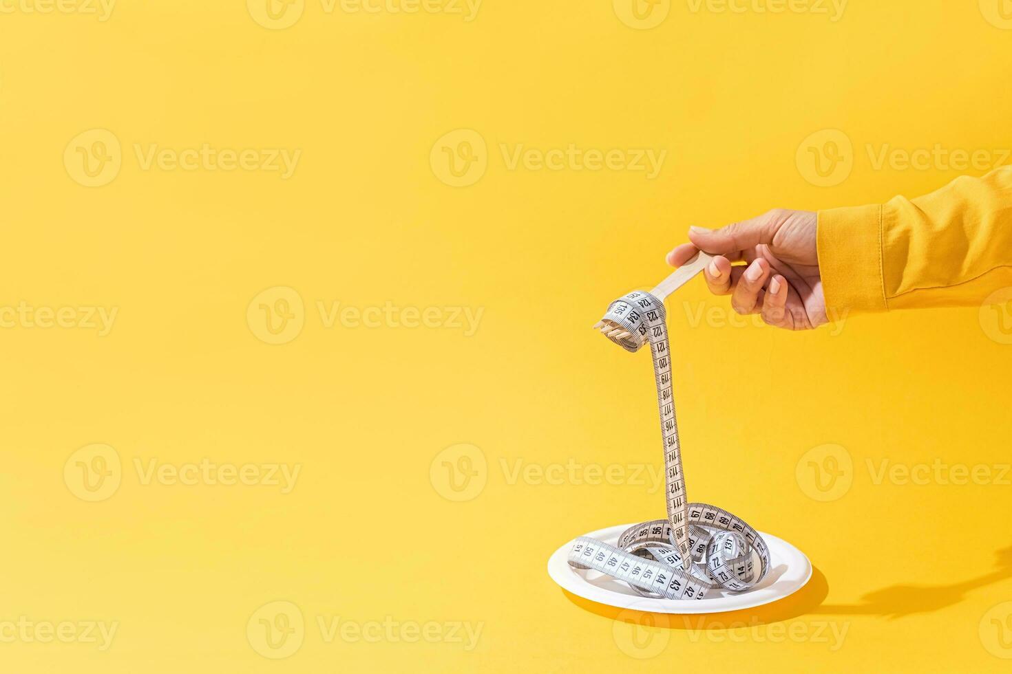 Frau Hände halten bunt Messung Band Vorderseite Aussicht auf Teller auf hell Gelb Hintergrund foto