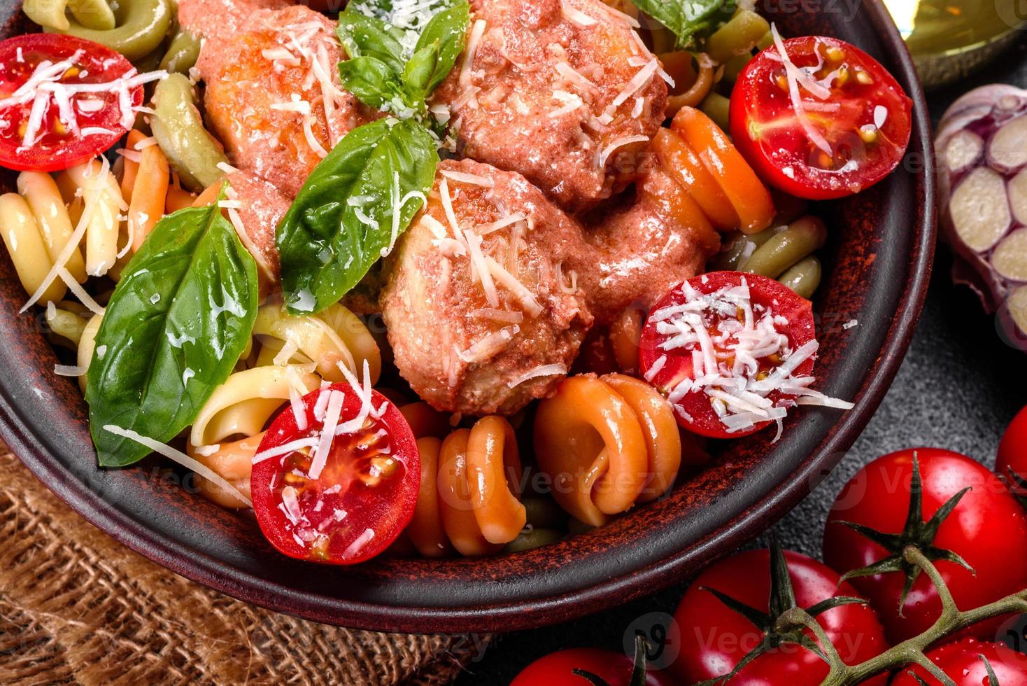 leckere frische Pasta mit Fleischbällchen, Sauce, Cherrytomaten und Basilikum foto