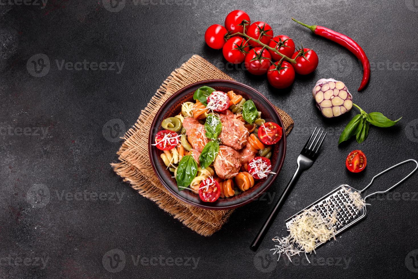 leckere frische Pasta mit Fleischbällchen, Sauce, Cherrytomaten und Basilikum foto