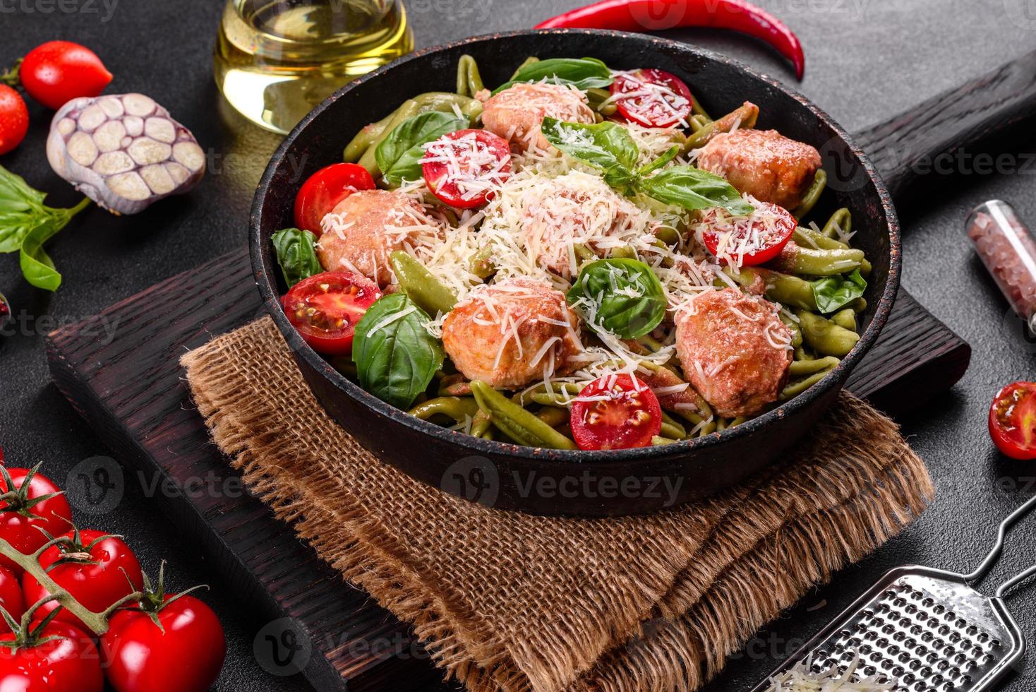 leckere frische Pasta mit Fleischbällchen, Sauce, Cherrytomaten und Basilikum foto