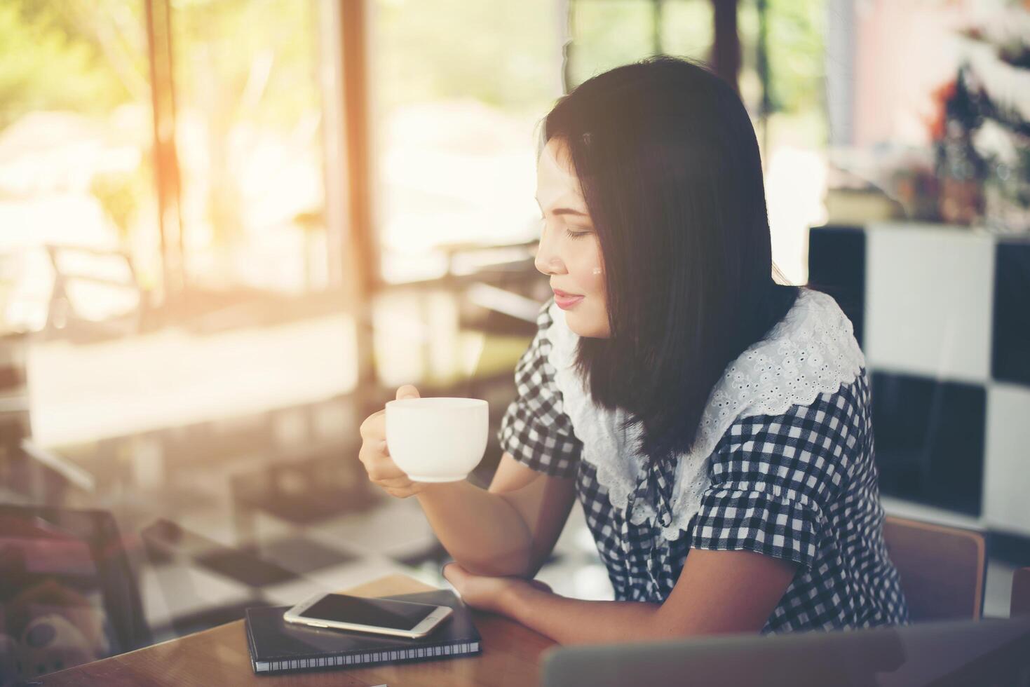 schöne Frau, die im Café sitzt und Kaffee trinkt. foto