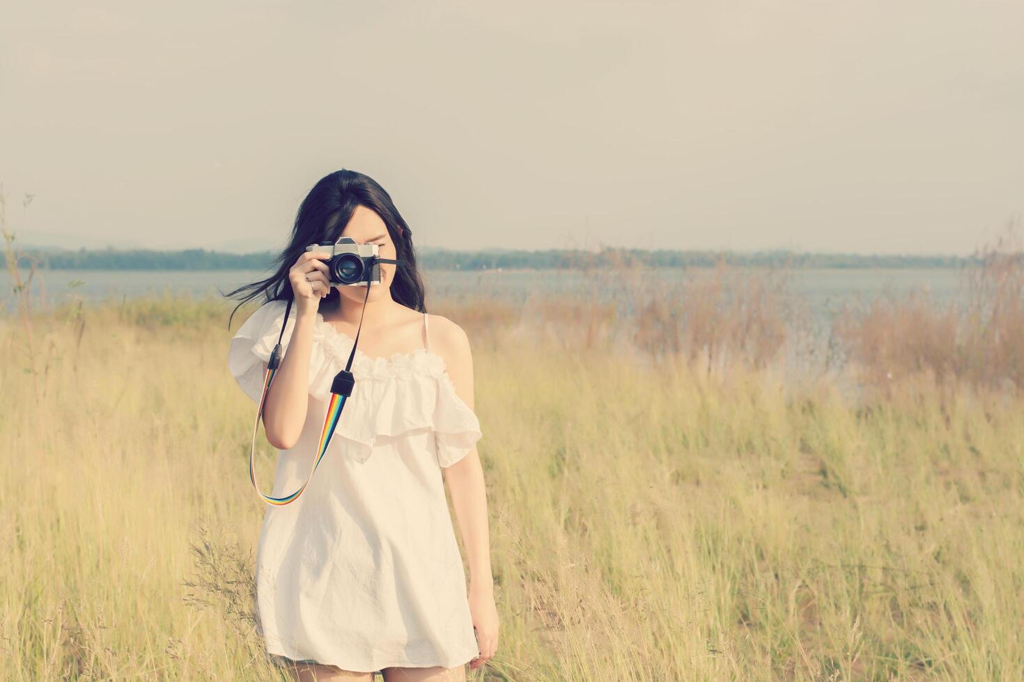 Jahrgang der stehenden Hand der Frauenfotografie, die Retro- Kamera hält. foto