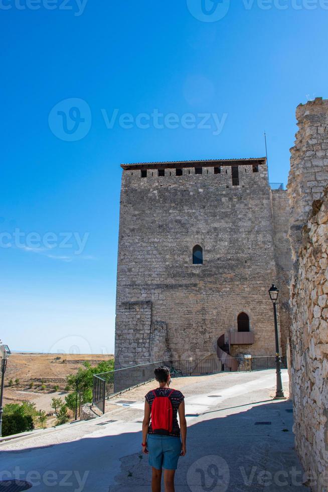 Frau geht vor einem mittelalterlichen Steinturm foto