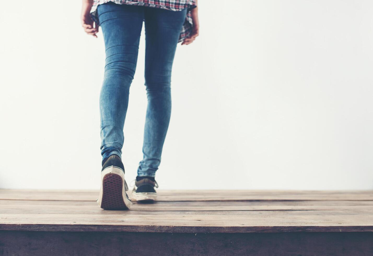 Hipster coole Frauenfüße mit schwarzen Sneakers, sanfte Vintage-Töne foto