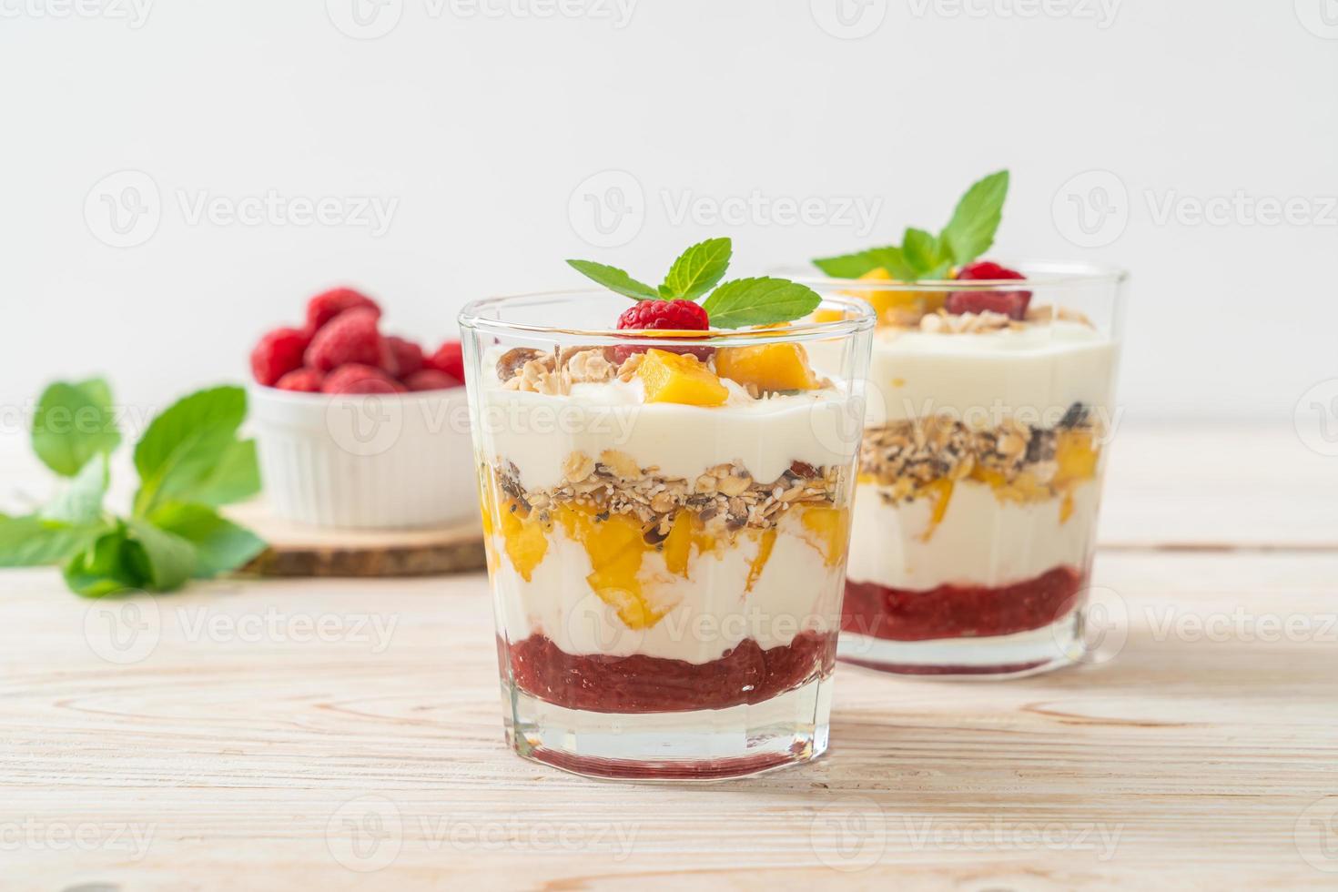 hausgemachte frische Mango und frische Himbeere mit Joghurt und Müsli - gesunder Ernährungsstil foto