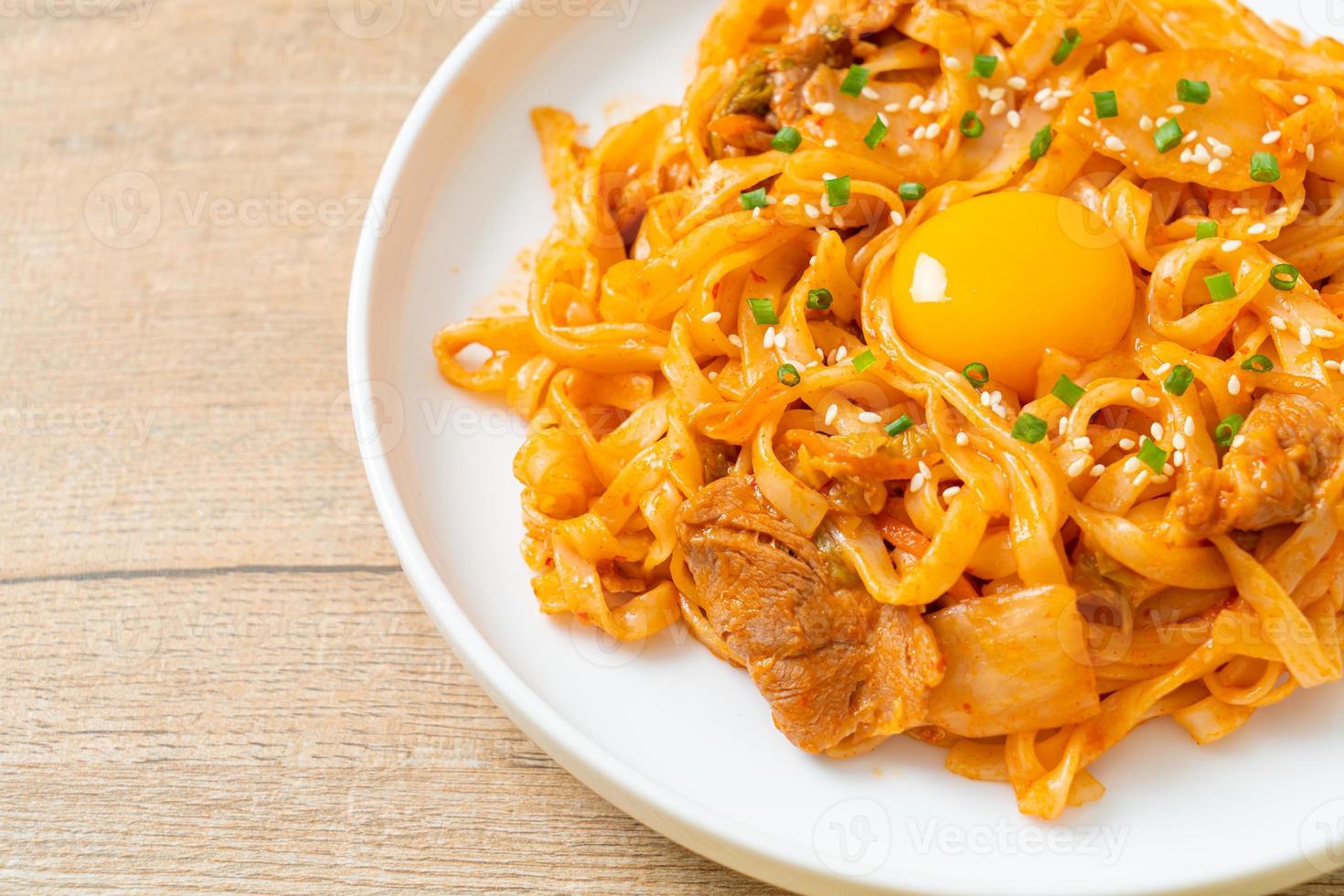 gebratene Udon-Nudeln mit Kimchi und Schweinefleisch - koreanische Küche foto