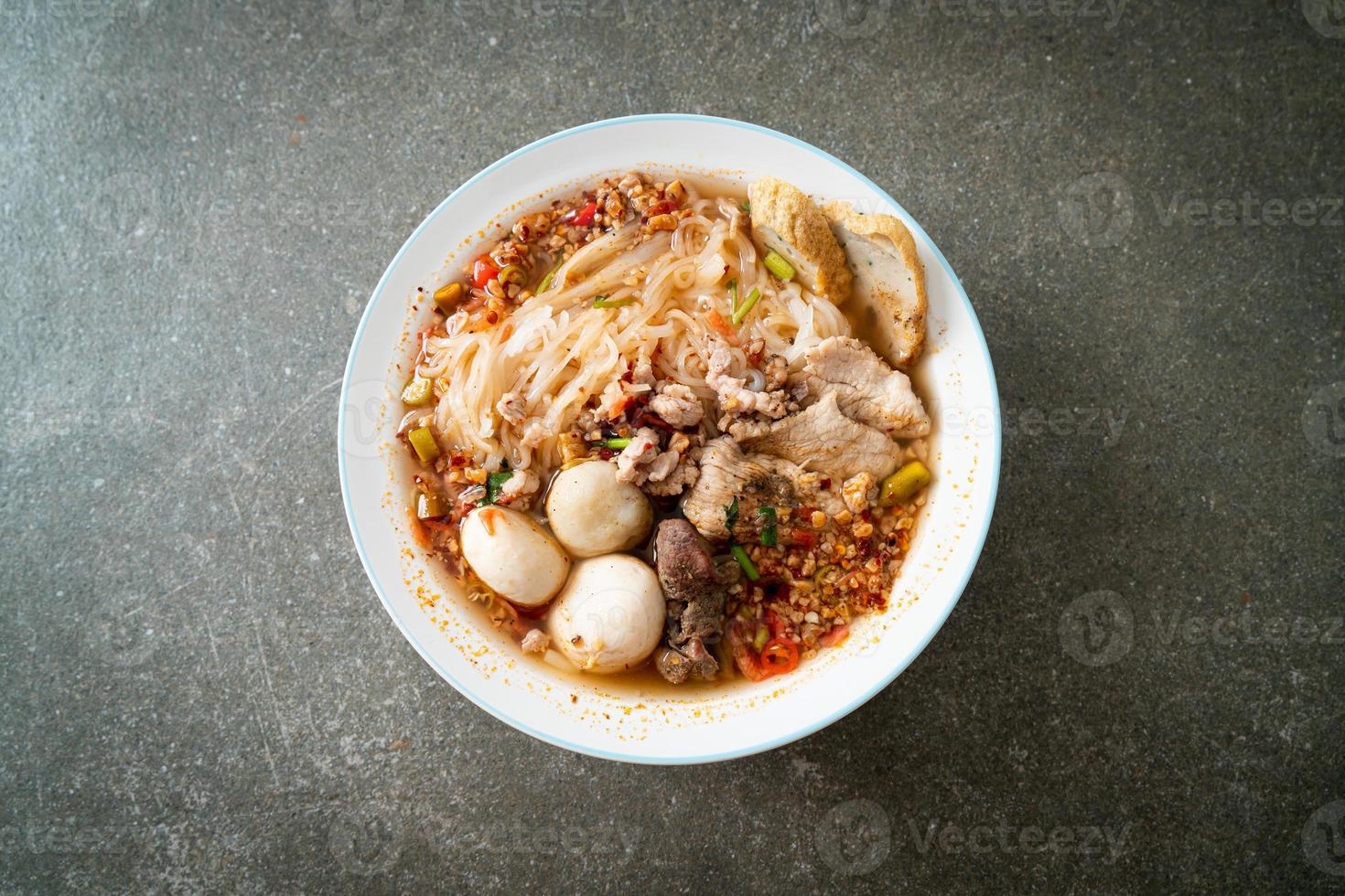 Nudeln mit Schweinefleisch und Frikadellen in scharfer Suppe oder Tom Yum Nudeln nach asiatischer Art foto