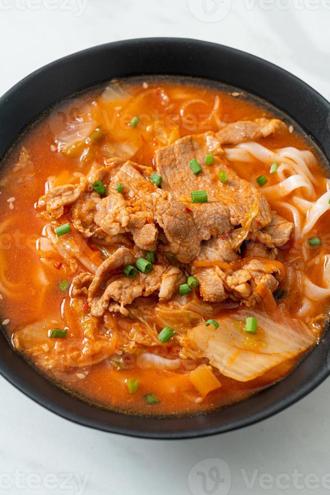 koreanische Udon-Ramen-Nudeln mit Schweinefleisch in Kimchi-Suppe foto