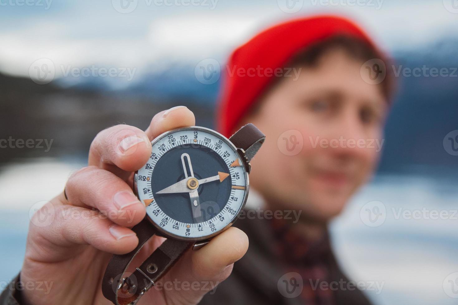 Reisender hält einen alten Kompass gegen foto