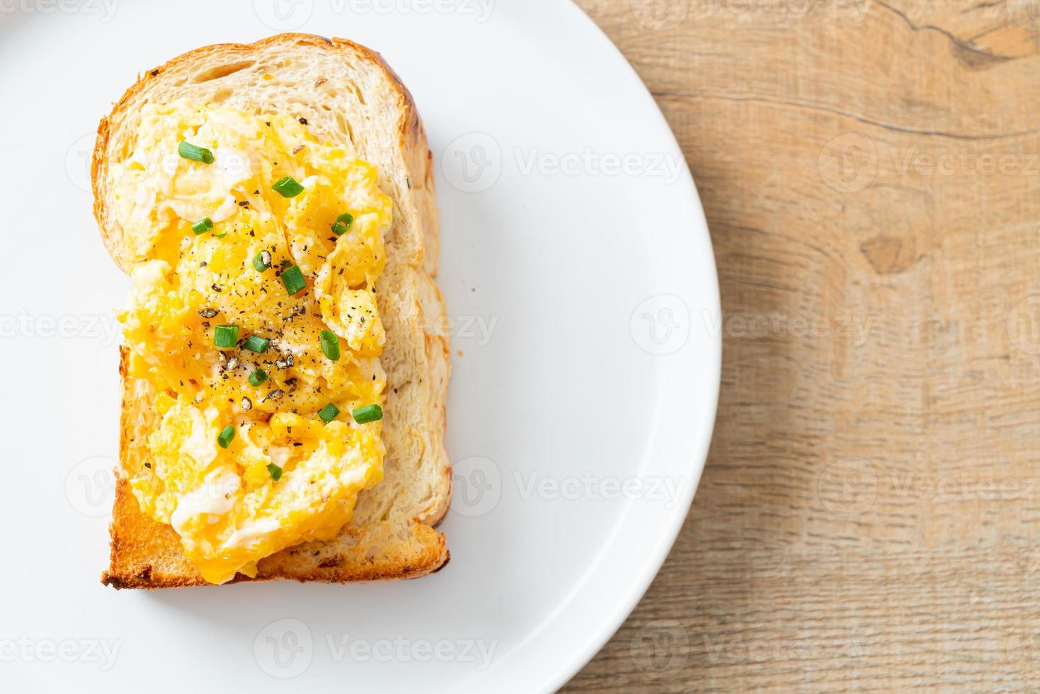 Brottoast mit Rührei auf weißem Teller foto