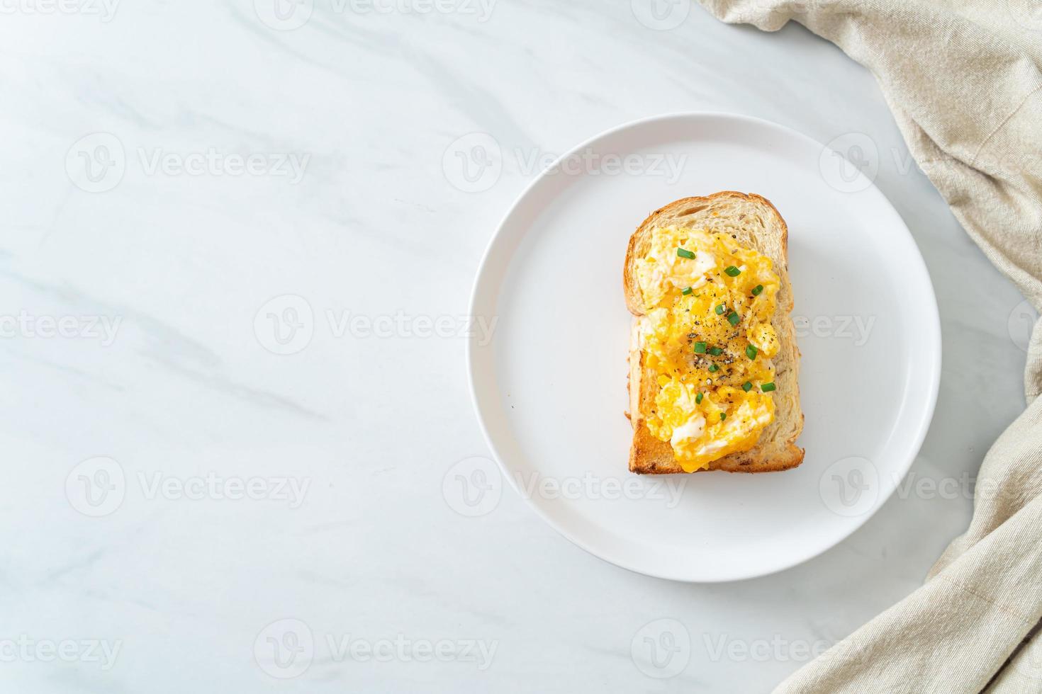 Brottoast mit Rührei auf weißem Teller foto