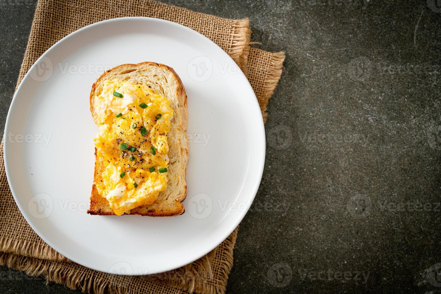 Brottoast mit Rührei auf weißem Teller foto