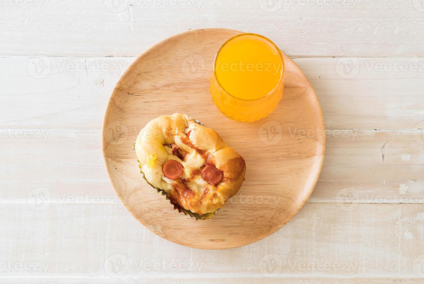 Wurst-Mayonnaise-Brot mit Orangensaft auf Holzplatte foto