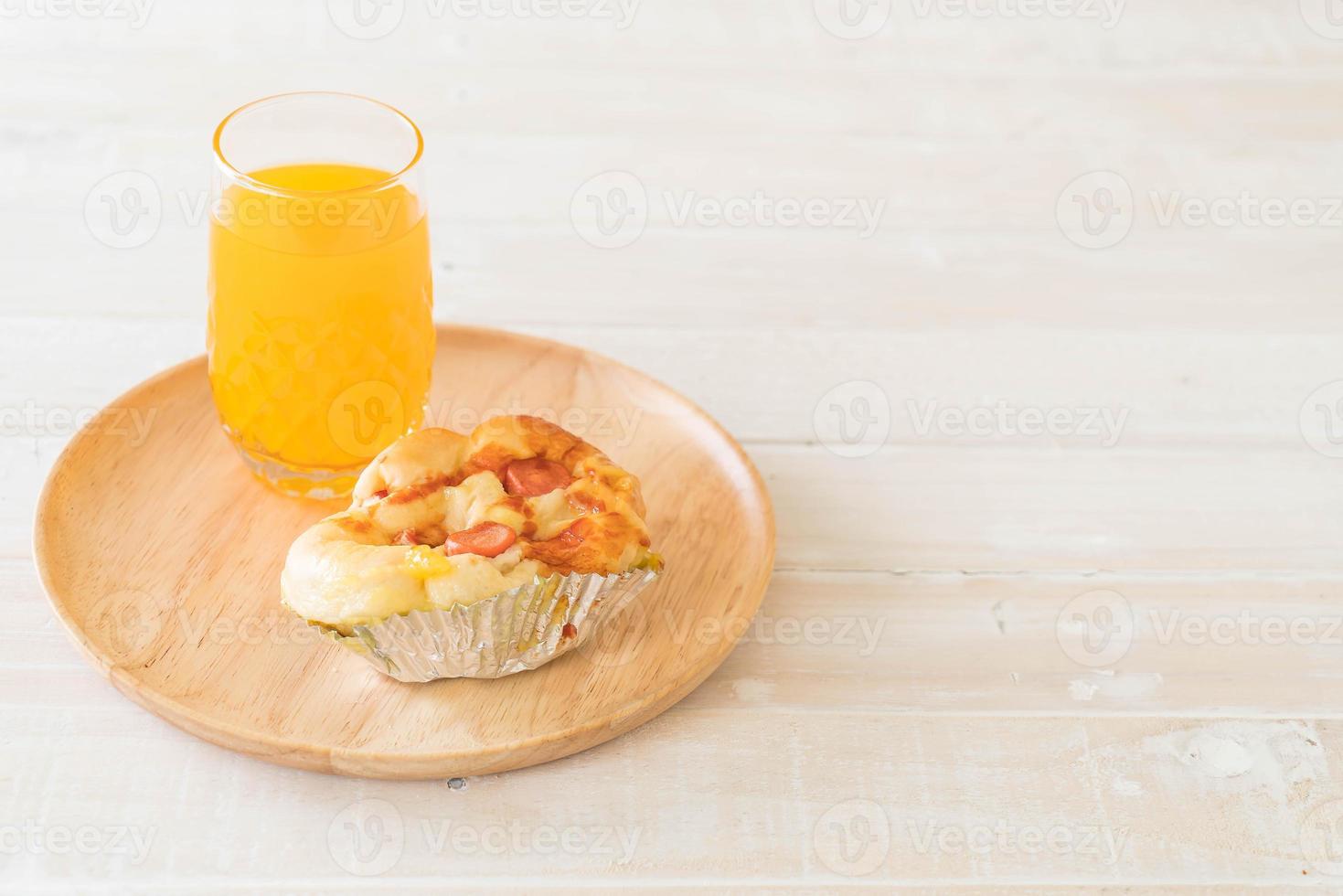 Wurst-Mayonnaise-Brot mit Orangensaft auf Holzplatte foto