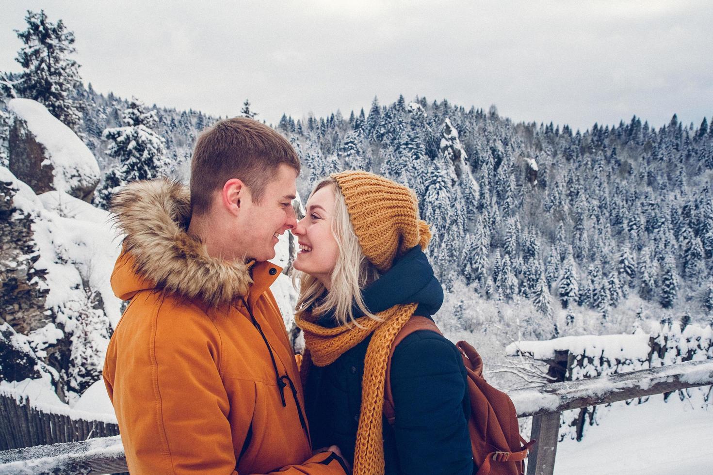 Liebespaar kuschelt draußen in einer Schneelandschaft foto