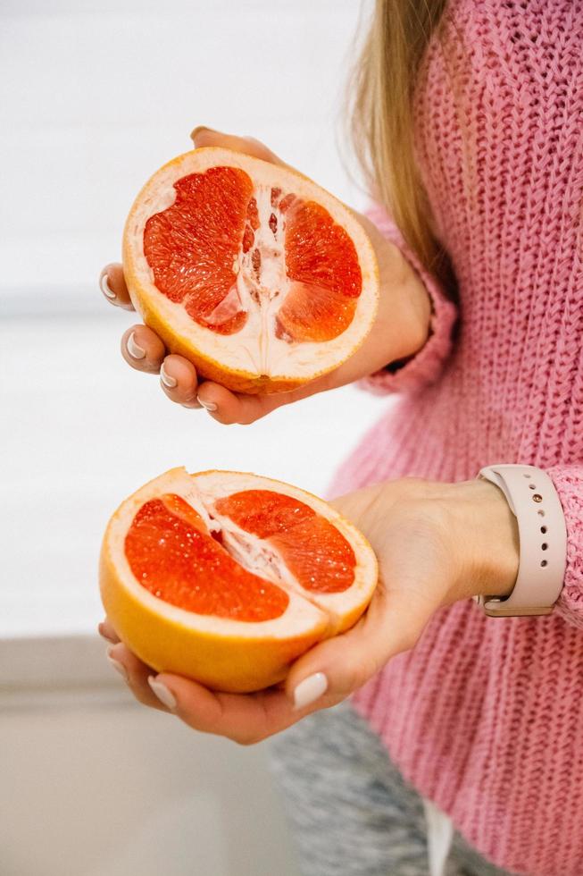 Frau mit geschnittener Grapefruit foto