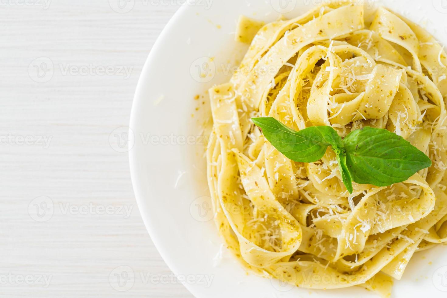 Pesto-Fettuccine-Nudeln mit Parmesan-Käse obenauf - italienische Küche foto