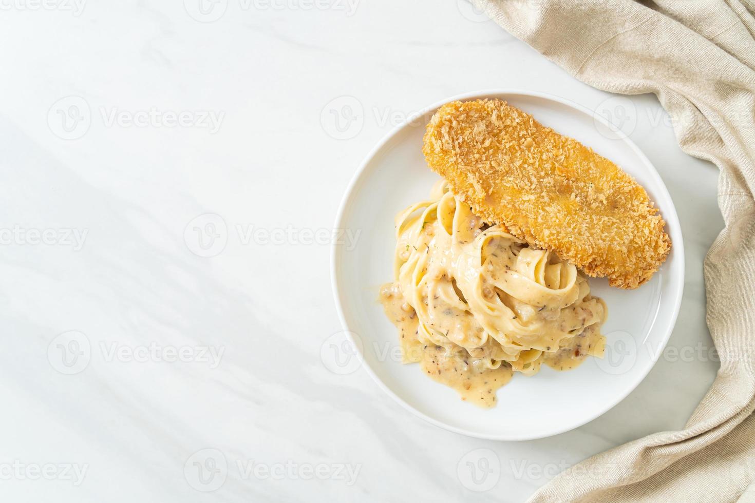 hausgemachte Fettuccine Pasta weiße Sahnesauce mit gebratenem Fisch foto