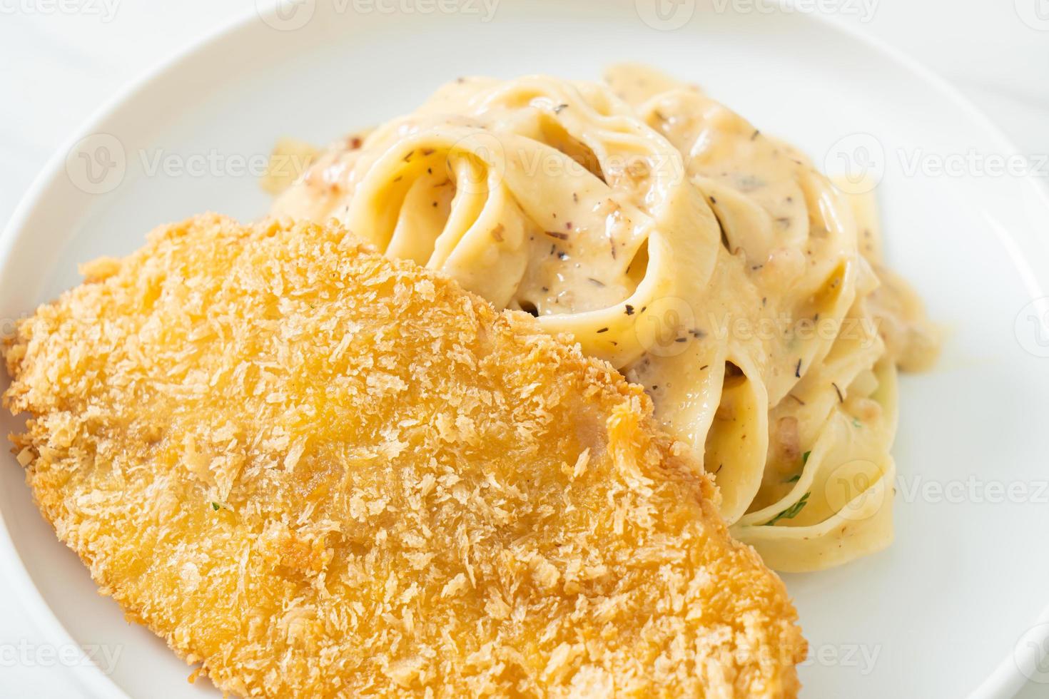 hausgemachte Fettuccine Pasta weiße Sahnesauce mit gebratenem Fisch foto