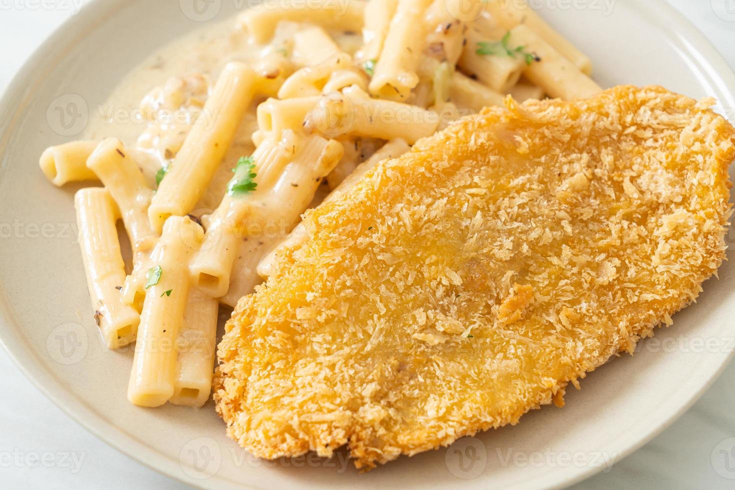 hausgemachte Quadrotto Penne Pasta weiße Sahnesauce mit gebratenem Fisch foto