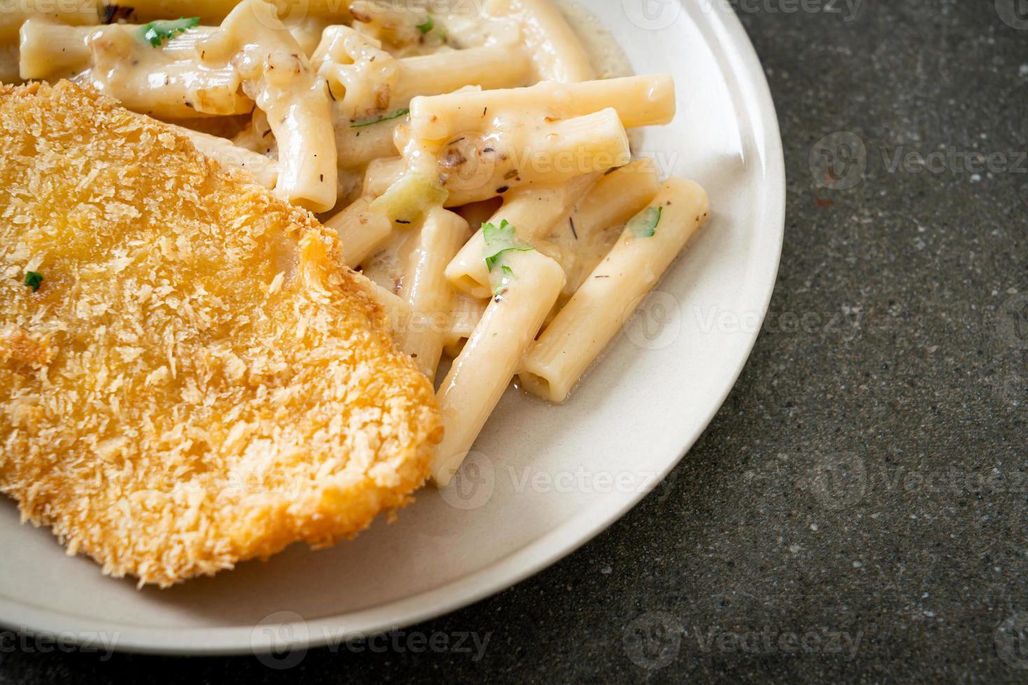 hausgemachte Quadrotto Penne Pasta weiße Sahnesauce mit gebratenem Fisch foto