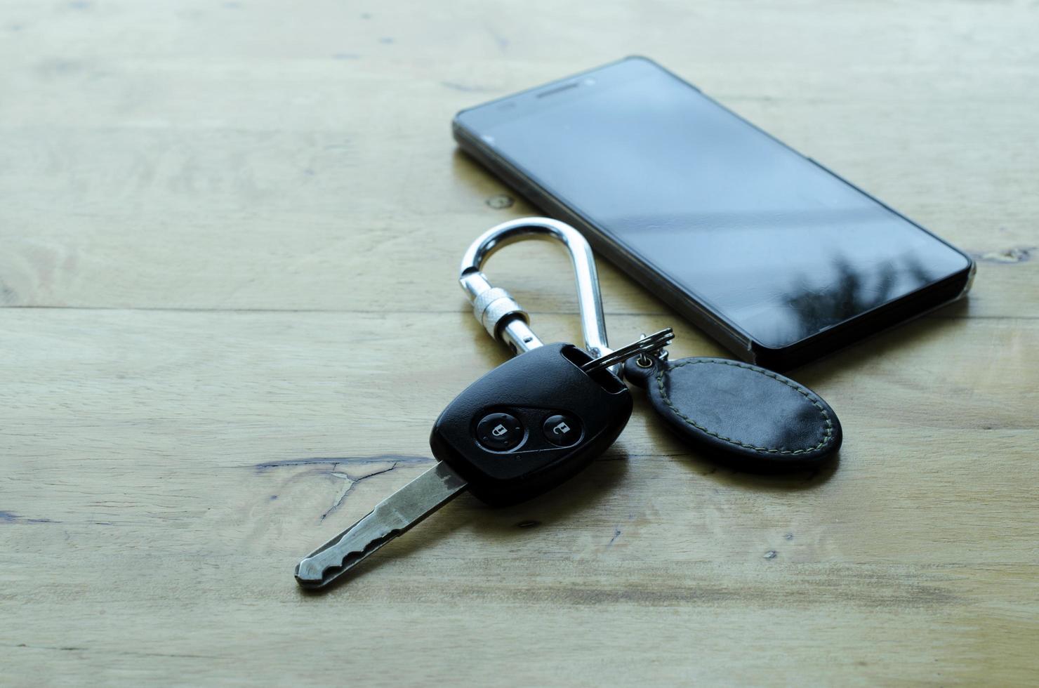 Autoschlüssel und Smartphone auf Holztischhintergründen foto