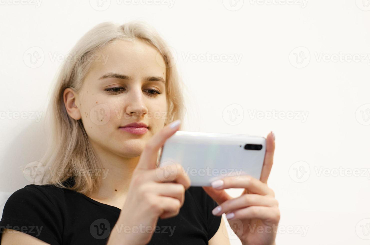 Das Mädchen sieht sich am Telefon ein Lehrvideo an. foto