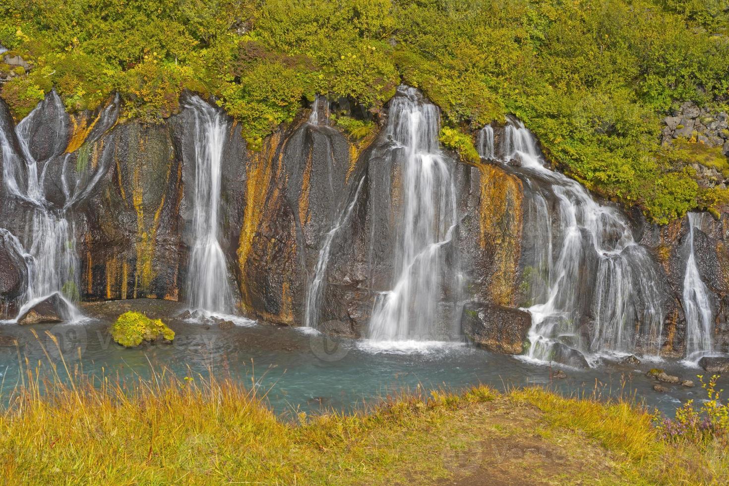 ruhige Wasserfälle fließen aus dem Vulkangestein foto