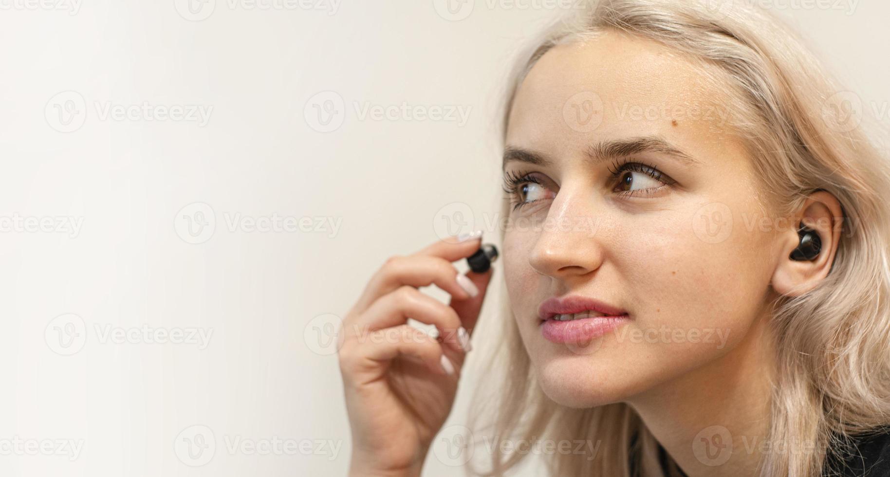 Mädchen setzt drahtlose Kopfhörer auf. moderne Technologien. foto