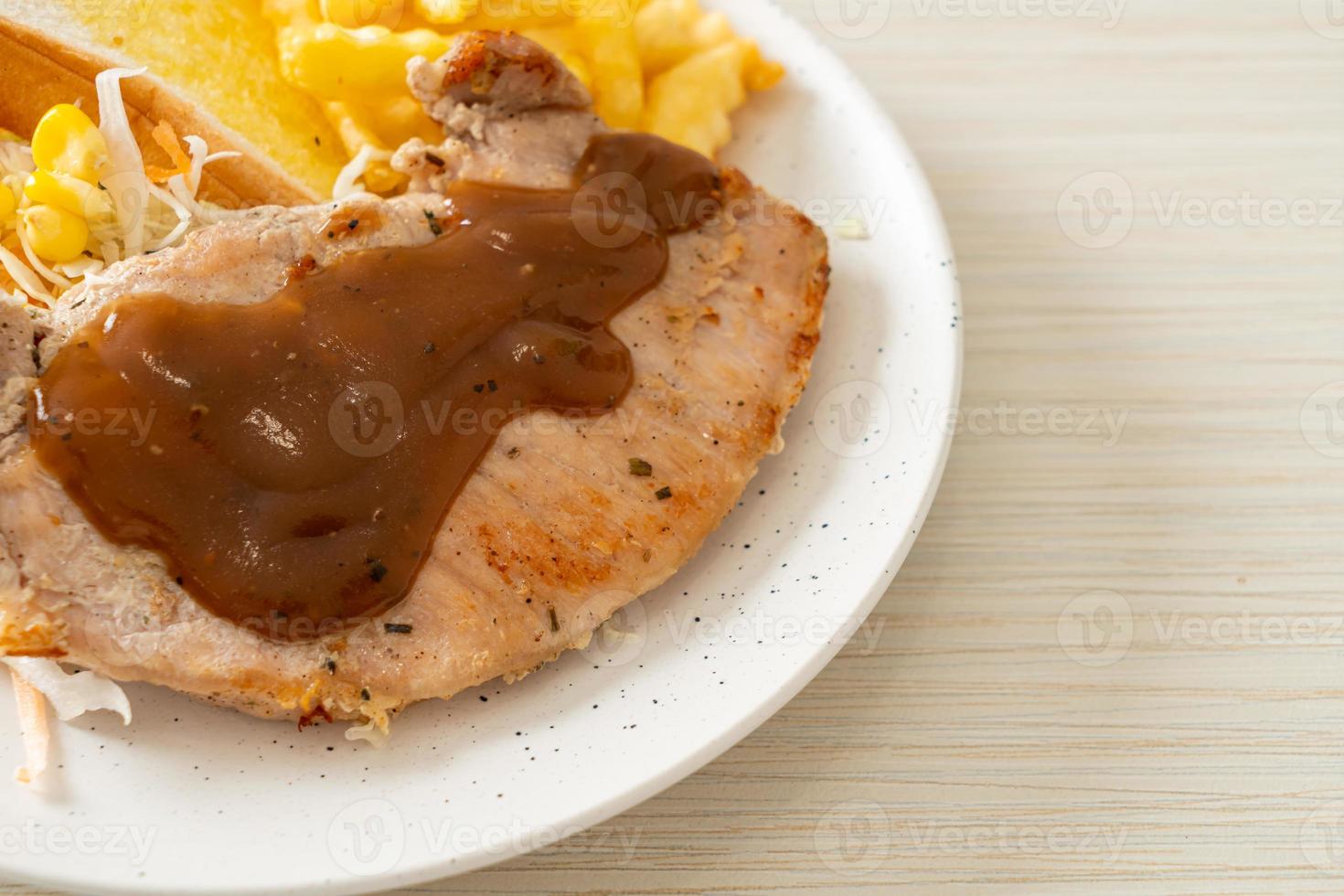 Schweinesteak mit schwarzer Paprikasauce und Minisalat foto