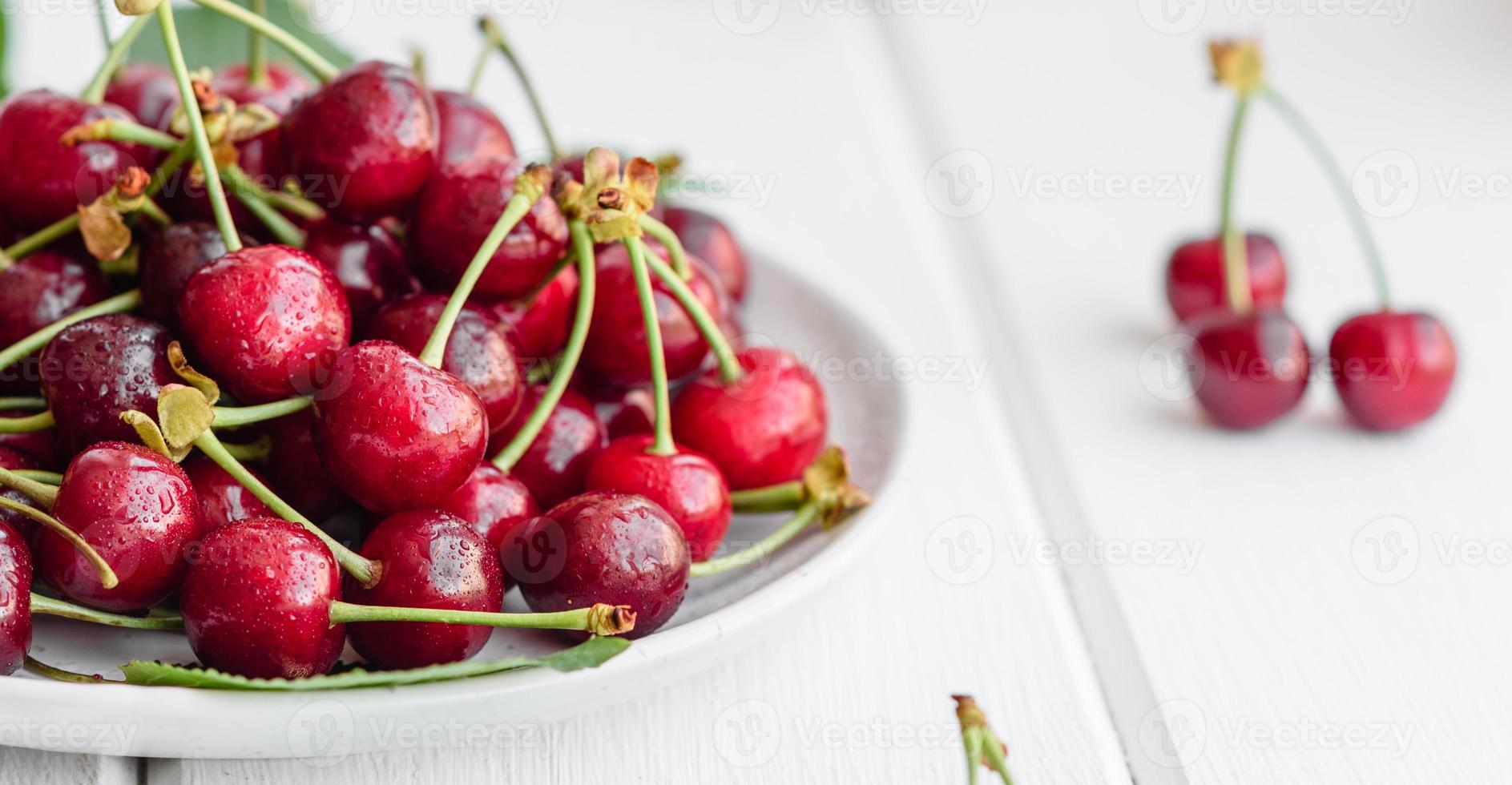 frische köstliche rote leuchtende Kirschbeeren im Sommergarten gerissen foto