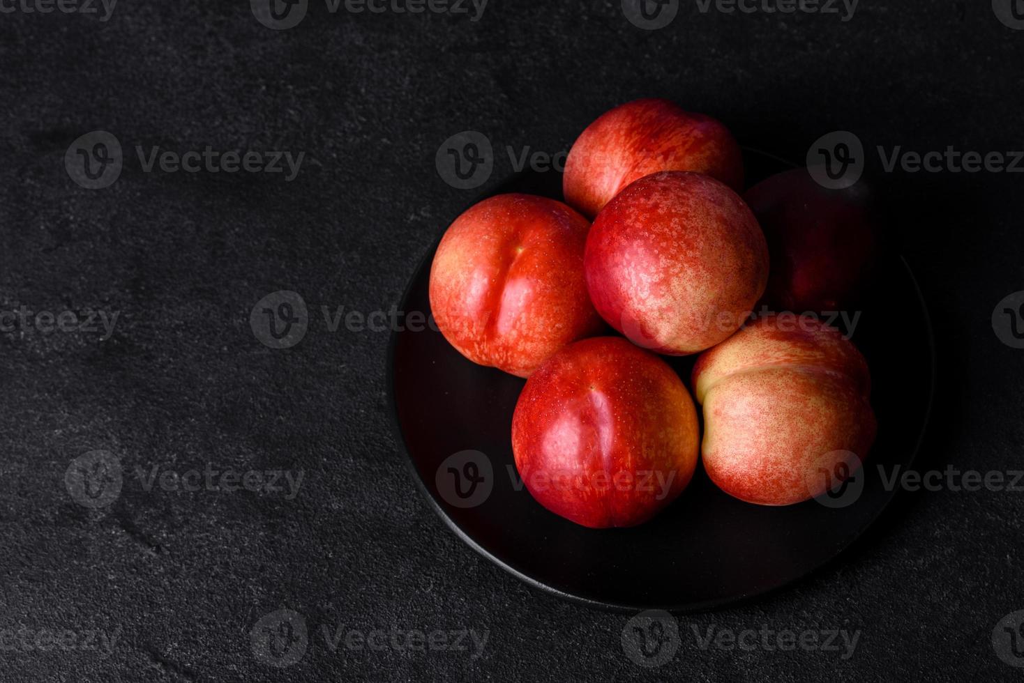 leckere süße Pfirsiche oder Nektarinen in einer braunen Schüssel foto