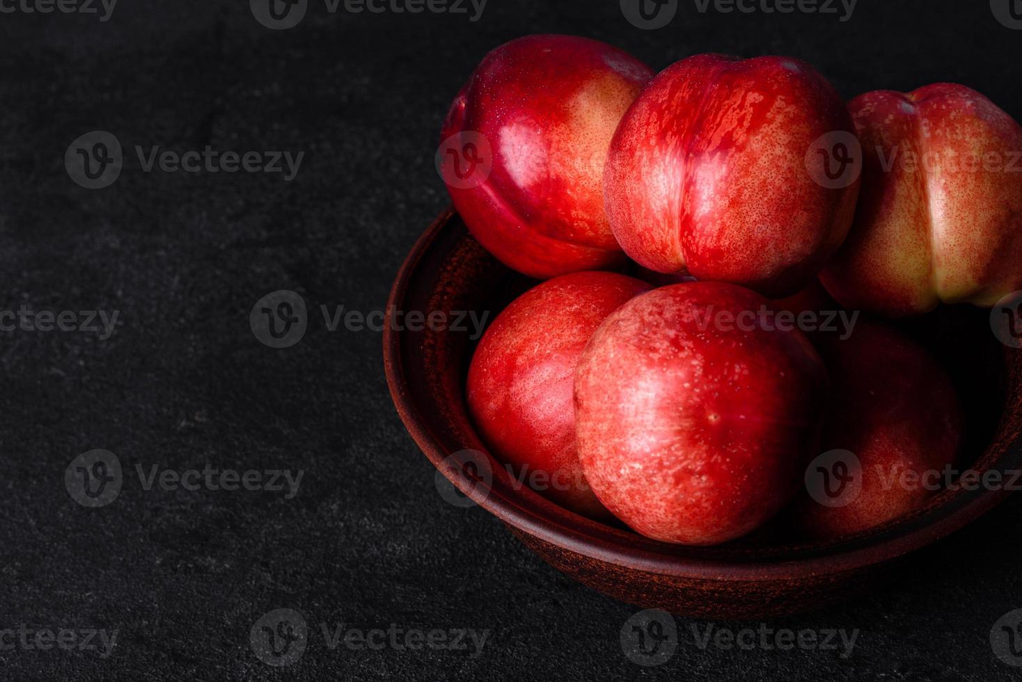 leckere süße Pfirsiche oder Nektarinen in einer braunen Schüssel foto