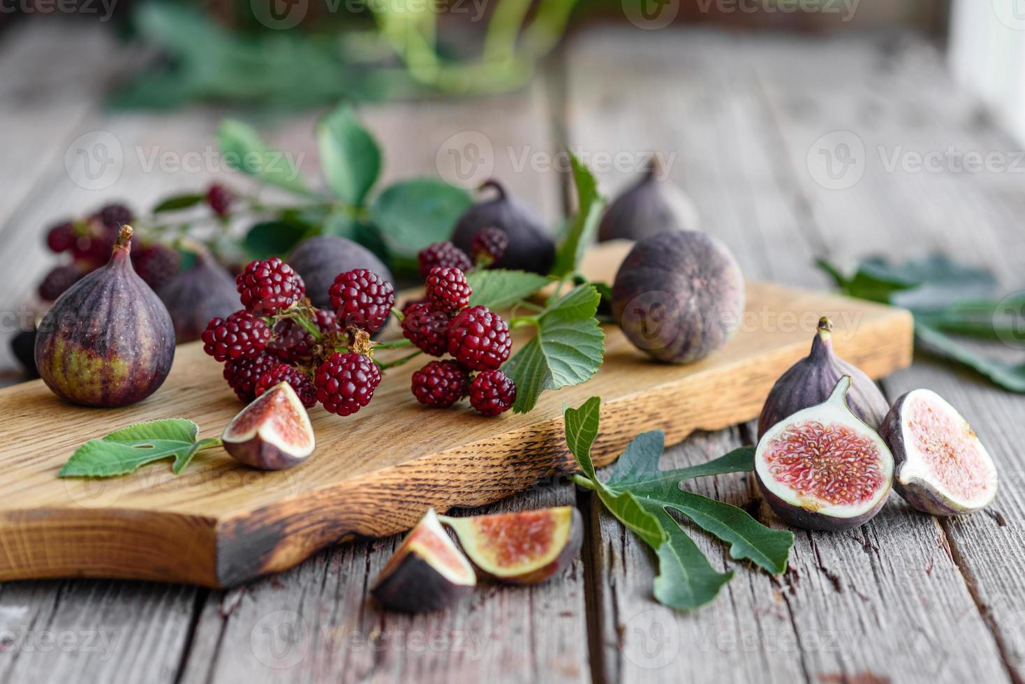 frische saftige Feigen und Brombeeren auf dunklem Hintergrund foto