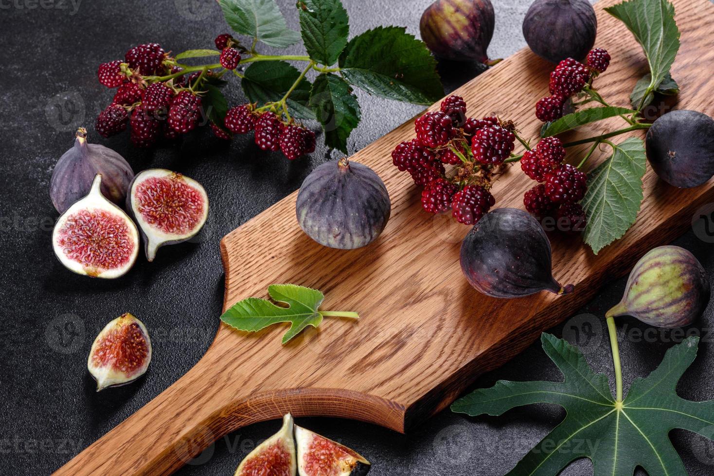 frische saftige Feigen und Brombeeren auf dunklem Hintergrund foto