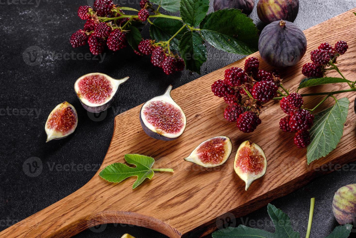 frische saftige Feigen und Brombeeren auf dunklem Hintergrund foto