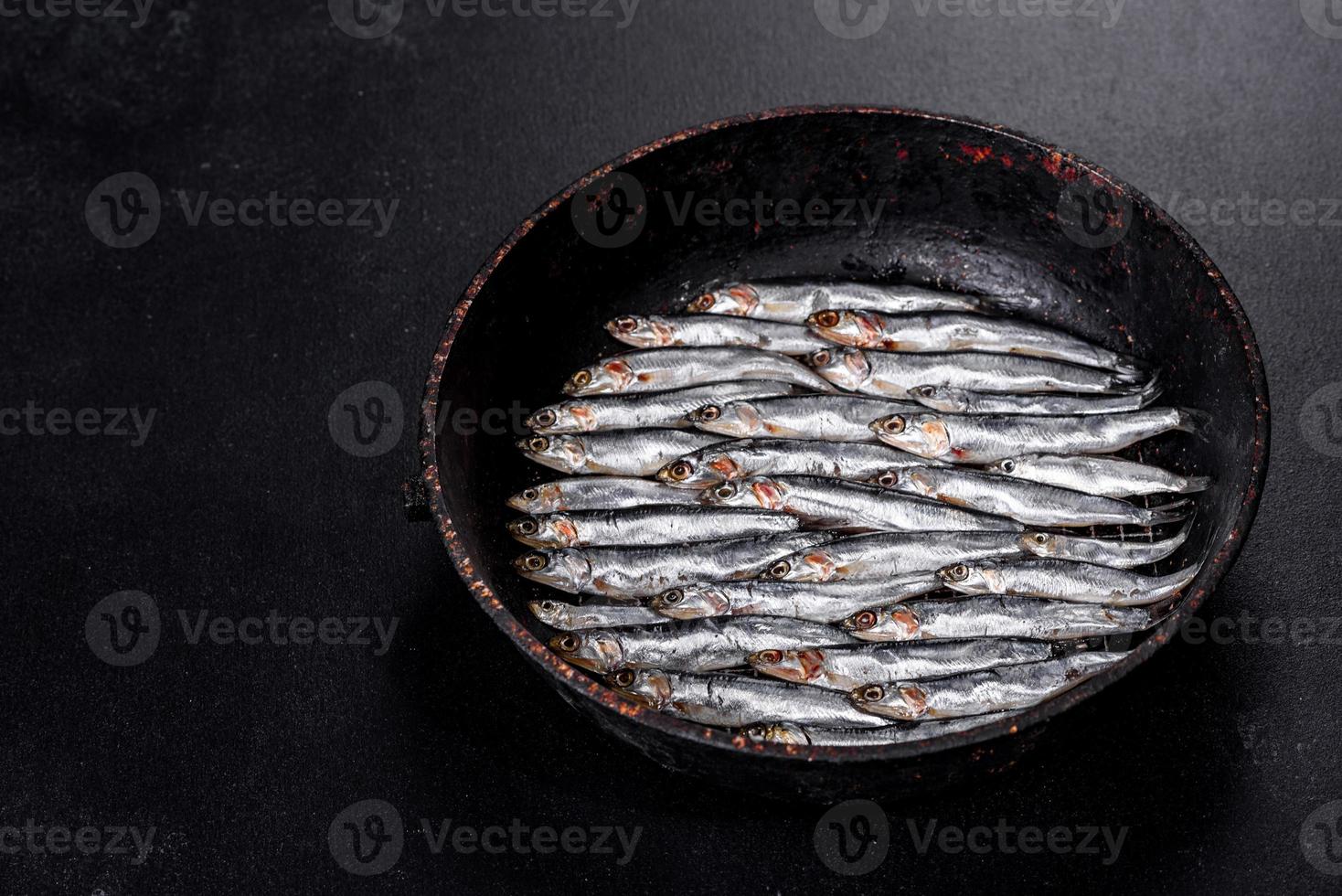 mehrere mit Fisch gesalzene Sardellen auf einem dunklen Betontisch foto