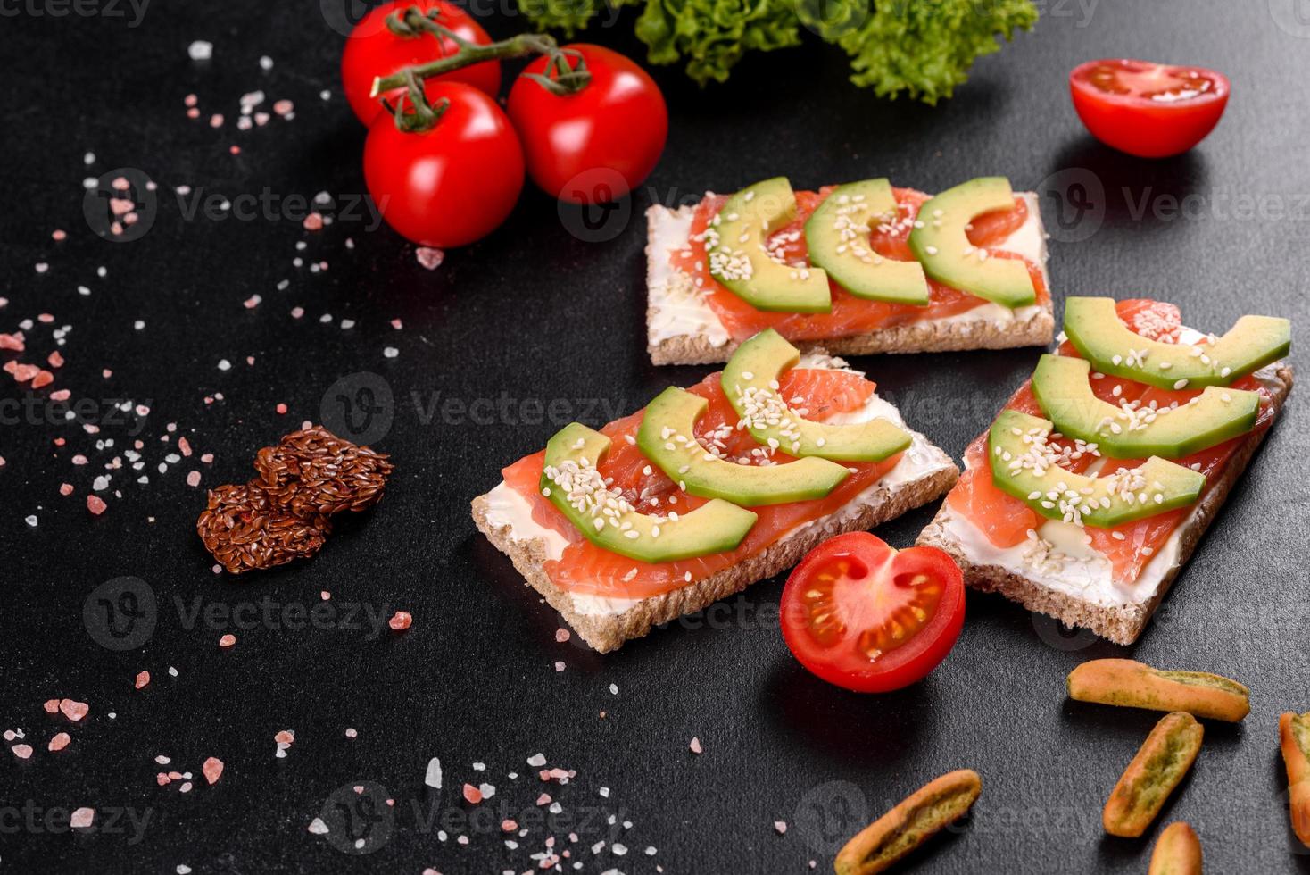 leckeres frisches Sandwich mit rotem Fisch, Butter, Brot und Avocado foto