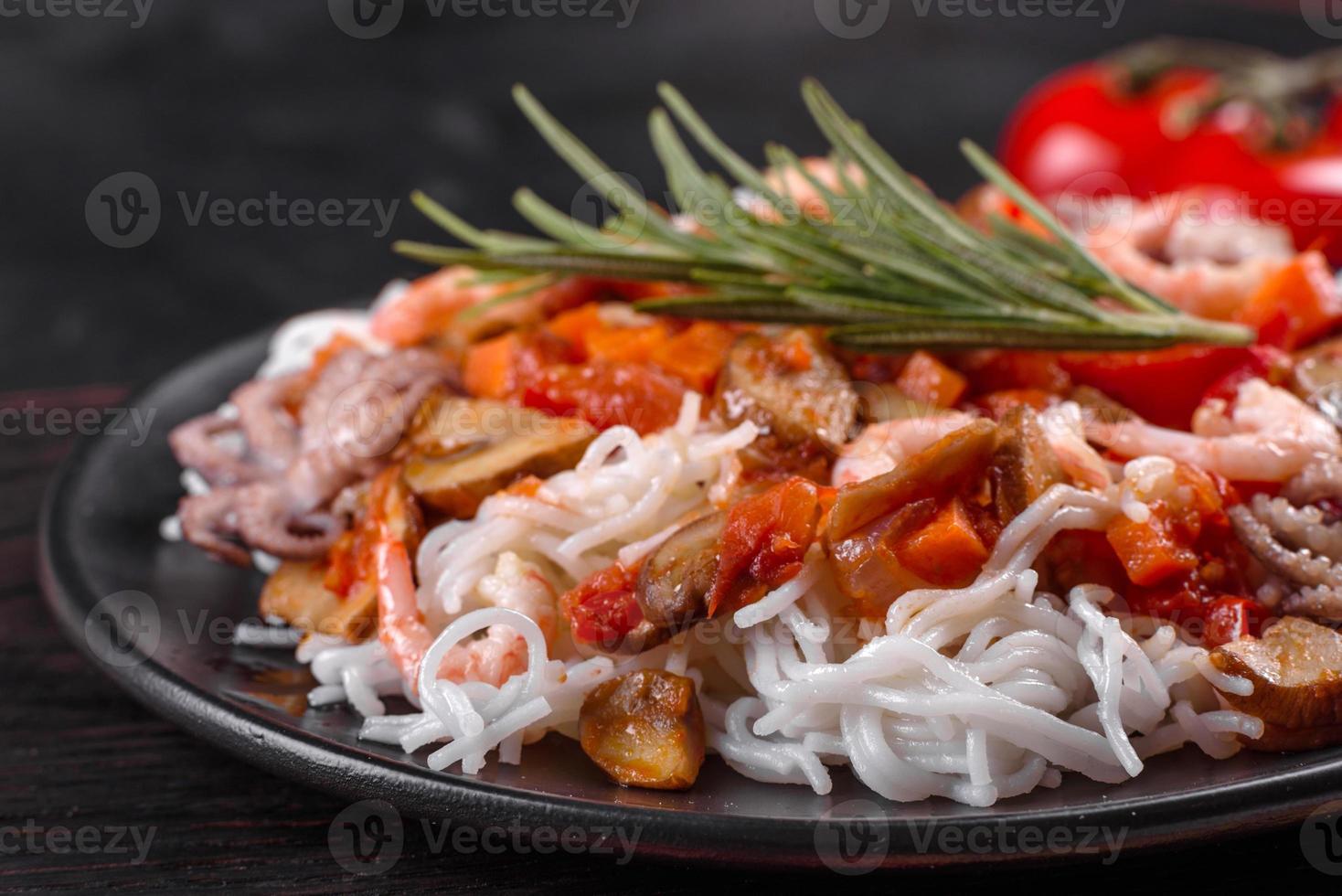 leckere Reisnudeln mit Tomaten, Paprika, Champignons und Meeresfrüchten foto