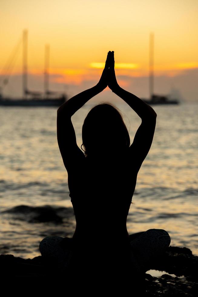 Frau, die Yoga an den Stränden von Formentera in Spanien praktiziert foto