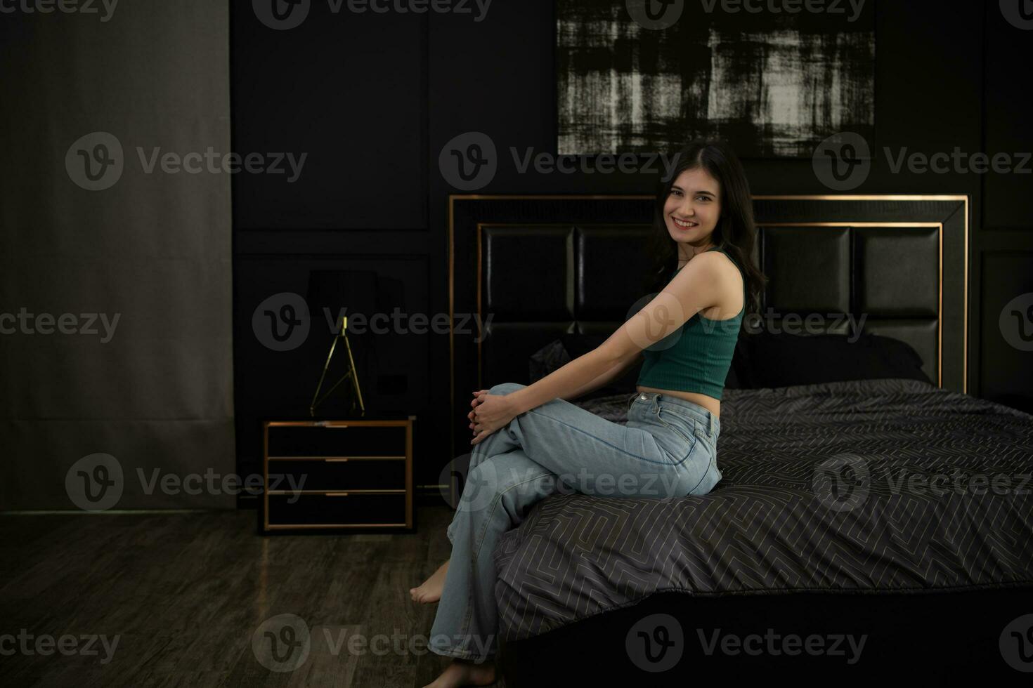 jung Frau Sitzung auf das Bett im das Zimmer beim Nacht Zeit. foto