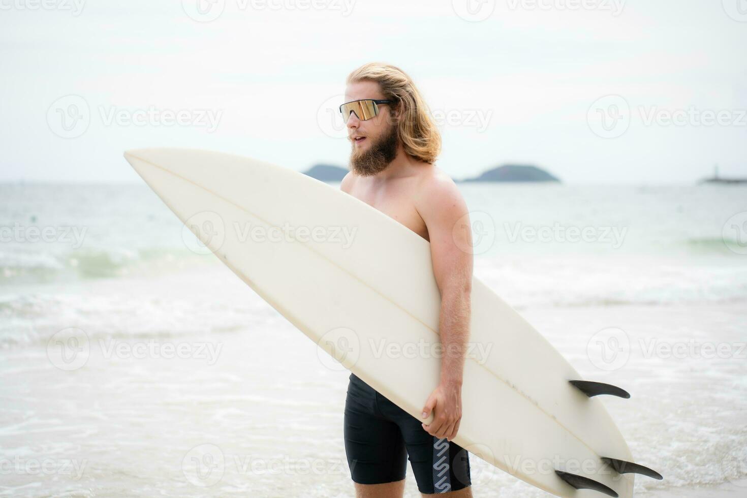 Surfer Mann mit seine Surfbrett auf das Strand. foto