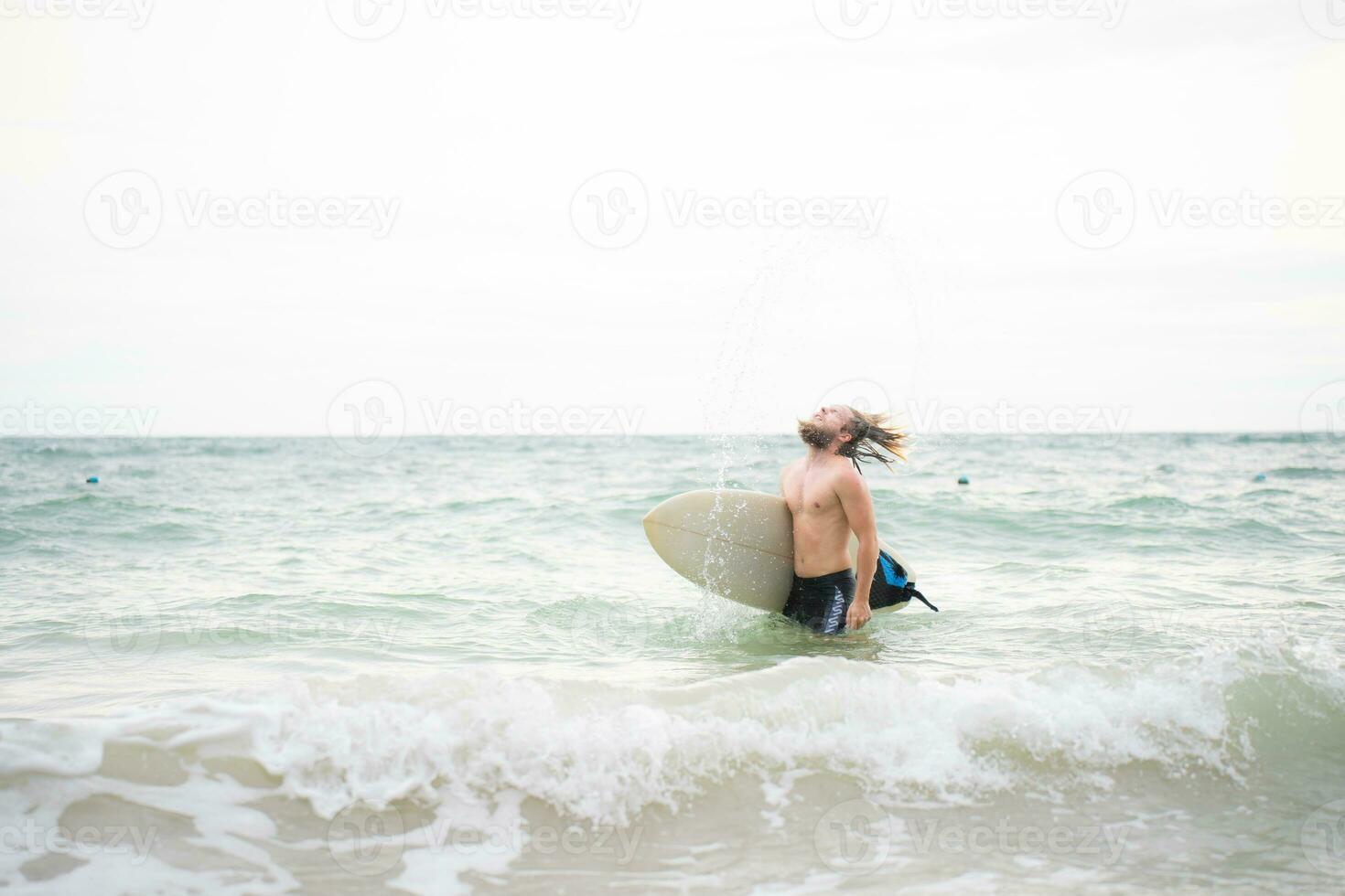 jung Mann Surfen auf das Strand haben Spaß und balancieren auf das Surfbrett foto