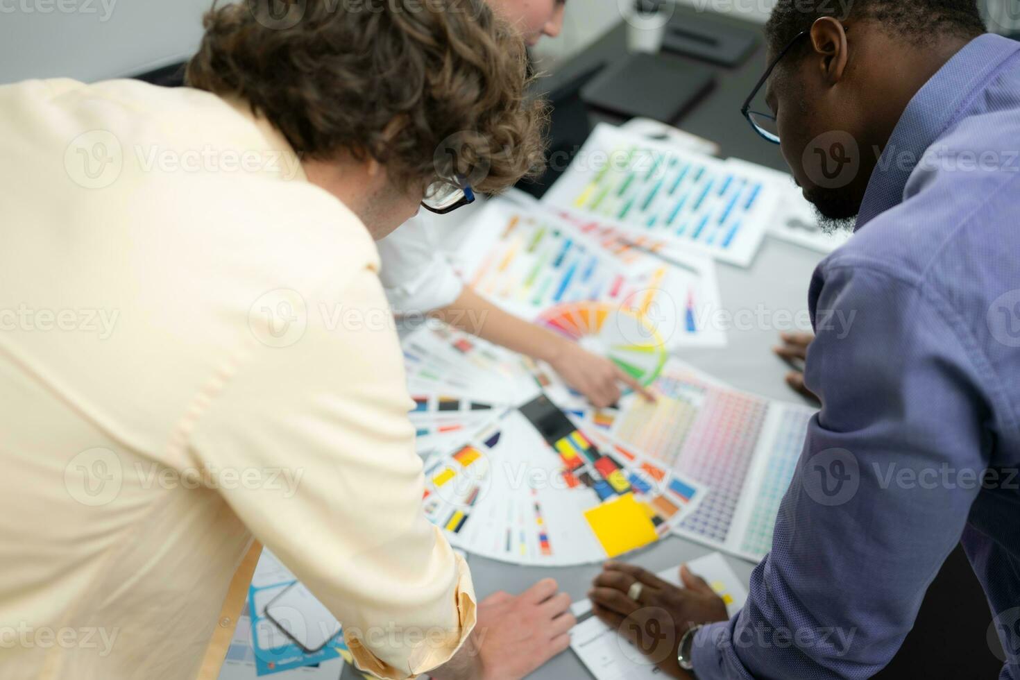 multiethnisch Mannschaft von Architekten und Designer sind Treffen zu Brainstorming Design ein Anwendung Smartphone auf ein hell modern Büro Arbeiten auf ein Laptop. foto