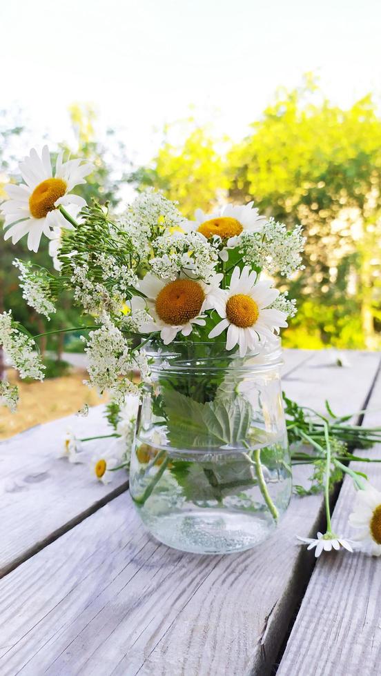 ein Strauß Gänseblümchen in einer Glasvase foto