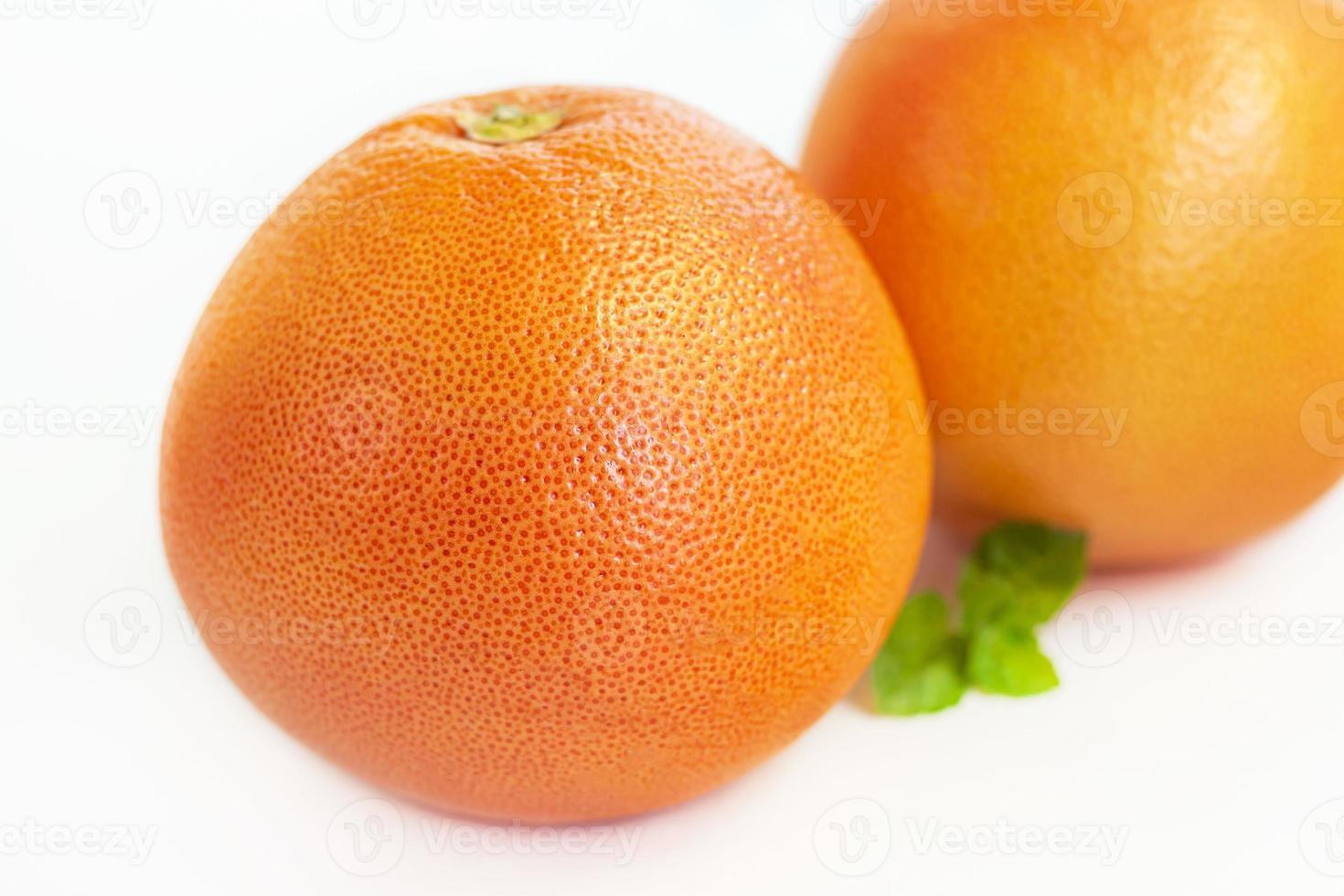 Grapefruit auf einem weißen Teller mit einem Zweig Minze. isolieren. foto
