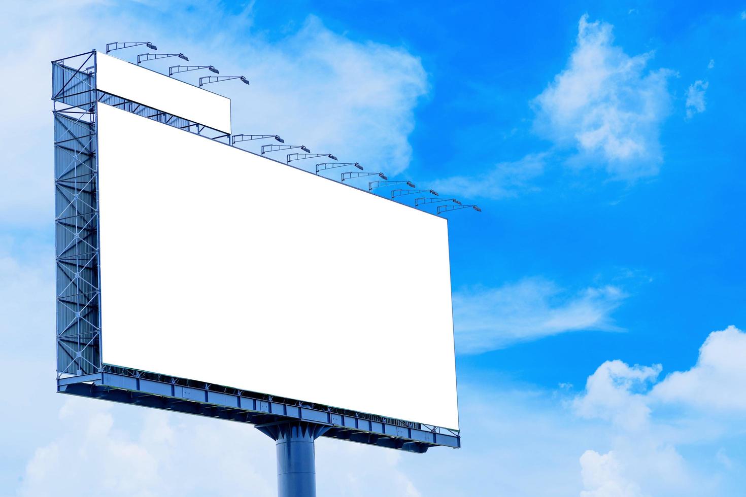leeres Billboard-Modell mit weißem Bildschirm gegen Wolken foto