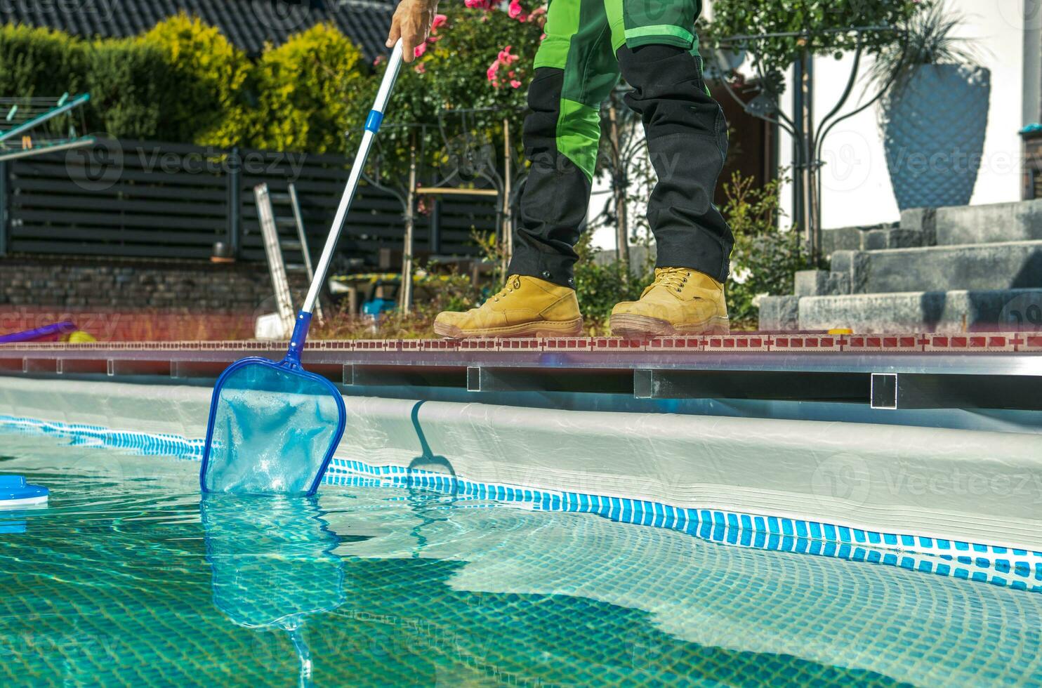 am Pool Instandhaltung Arbeiter Reinigung Wasser Oberfläche mit ein Netz foto