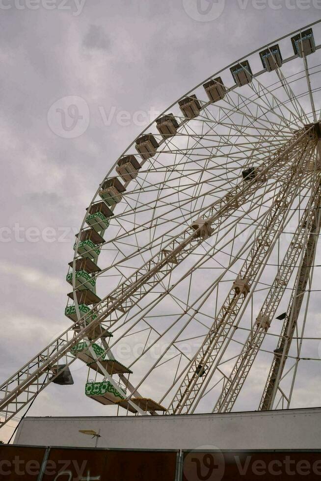 ein Ferris Rad ist gezeigt gegen ein wolkig Himmel foto